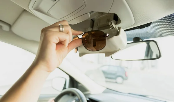 Frau holt Sonnenbrille aus speziellem Autoabteil — Stockfoto