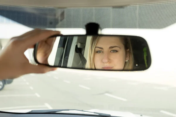 Fechar-se de mulher ajustando espelho do carro e olhando no refletir — Fotografia de Stock