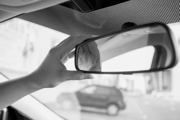 Closeup black and white photo of female driver adjusting rear vi — Stock Photo, Image