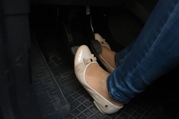 Close-up van vrouwelijke bestuurder voeten op de pedalen van de auto — Stockfoto