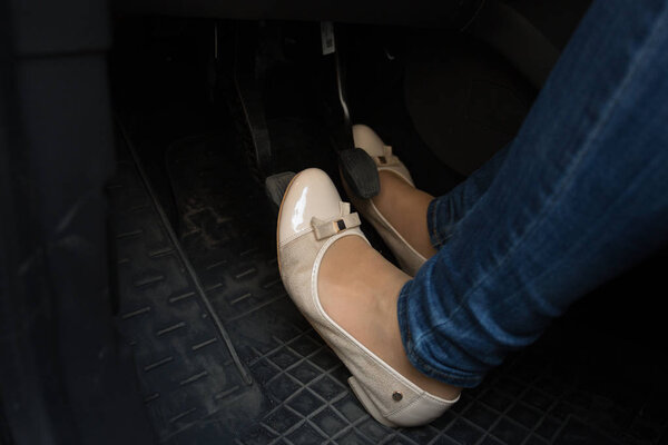 Closeup of female driver feet on car pedals