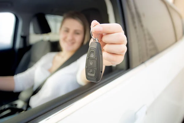 Улыбающаяся женщина за рулем автомобиля с ключами от машины — стоковое фото