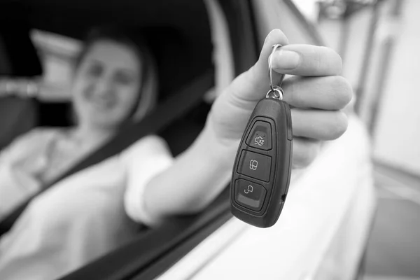 Foto de primer plano en blanco y negro de la mujer feliz mostrando las llaves del coche th — Foto de Stock