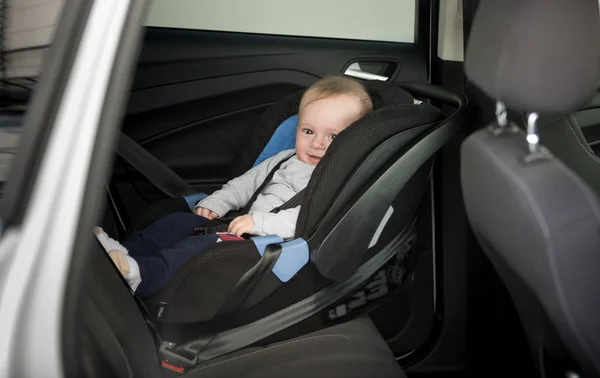 Niño de 6 meses sentado en el asiento del niño en el coche — Foto de Stock