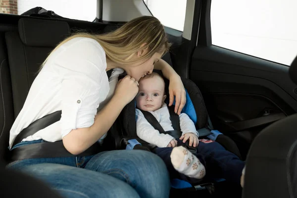 Feliz joven madre sentada en el asiento trasero con su bebé —  Fotos de Stock