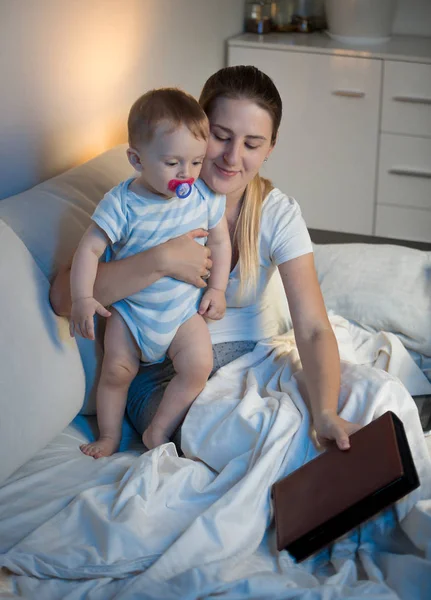 Portret van glimlachen moeder en schattige baby leesboek voor — Stockfoto