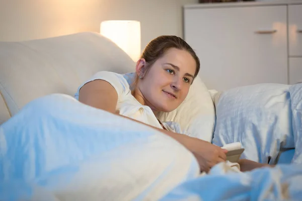 Wanita muda cantik menggunakan tablet digital di tempat tidur di malam hari — Stok Foto