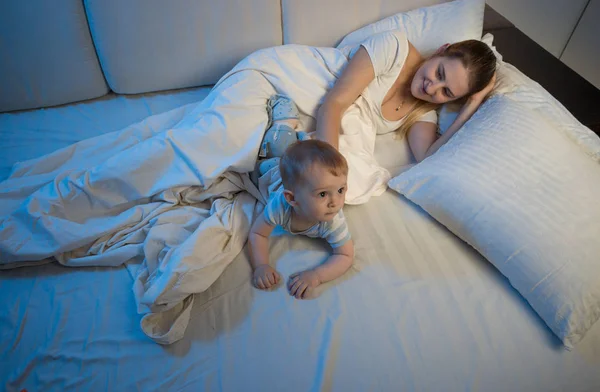 Junge Mutter schläft mit ihrem kleinen Jungen im Bett — Stockfoto