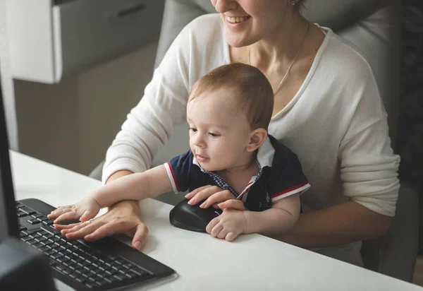 Uśmiecha się kobieta kobieta interesu, praca przy komputerze z chłopca siedzi — Zdjęcie stockowe