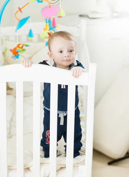 Söt 9 månader gammal baby pojke stående i babysäng — Stockfoto