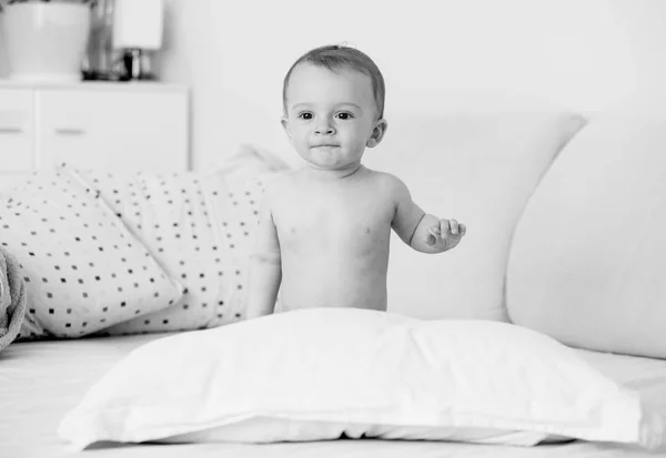 Preto e branco imagem de bonito bebê menino sentado na cama no quarto — Fotografia de Stock