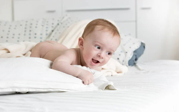 Adorable bebé niño arrastrándose en la cama grande en el dormitorio — Foto de Stock