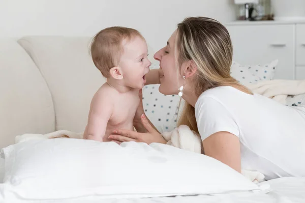 Retrato de bebé alegre con madre acostada sobre una gran almohada blanca —  Fotos de Stock