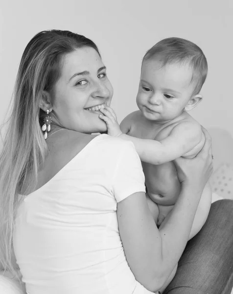 Черно-белый портрет молодой матери, целующейся и играющей в остроумие — стоковое фото