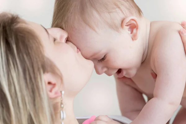 Entzückender kleiner Junge krabbelt auf dem Bauch der Mutter auf dem Bett — Stockfoto