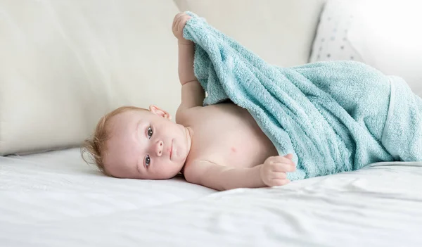 9 meses de idade menino sentado na cama sob toalha — Fotografia de Stock