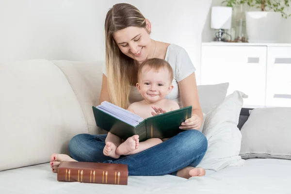 年轻的母亲阅读本书向她微笑的小男孩 — 图库照片