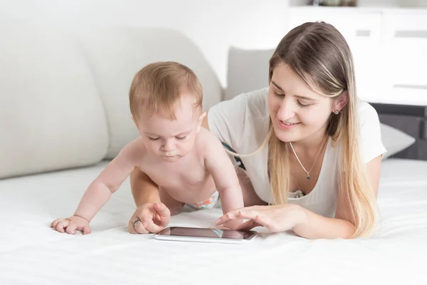 Bella giovane madre che insegna al suo bambino come tablet compu — Foto Stock