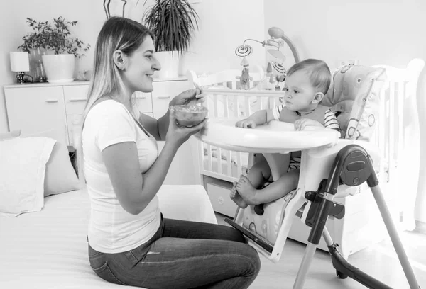Imagen monocromática de la hermosa madre joven alimentando a su bebé —  Fotos de Stock