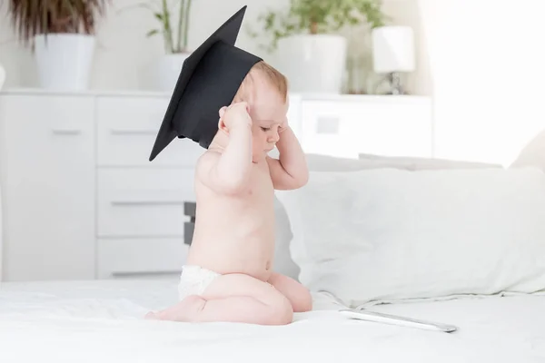 Niño en gorra de graduación mirando tableta digital — Foto de Stock