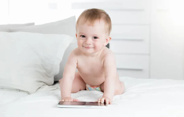 Adorable bébé garçon utilisant une tablette numérique sur le lit — Photo