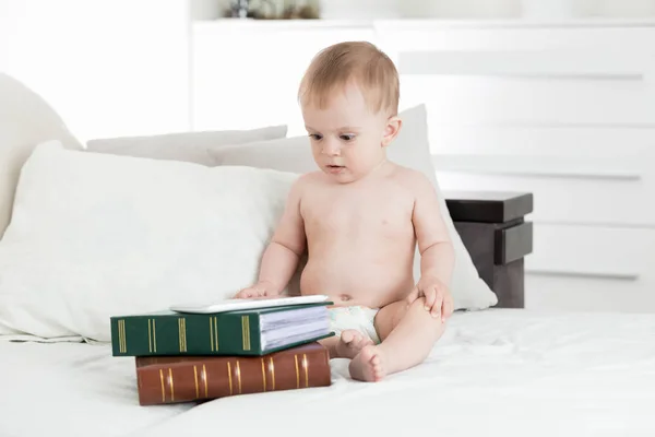 사랑 스러운 아기 책의 스택에 누워 디지털 테이블을 사용 하 여 — 스톡 사진