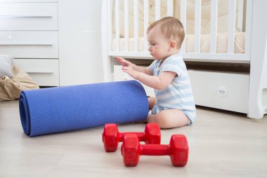 Dambıl ve fitness hasır ile oynayan bebek çocuk