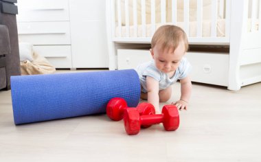 Kattaki fitness mat ve halter ile oynayan bebek. Kavramı