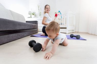 Bebek çocuk annesi egzersiz sırasında dumbbells ile oynamak