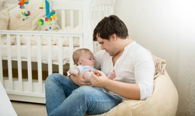 Mutlu baba bebek oğlu ile yatak odası boyuyla oturan