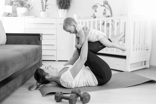 Black and white image of beautiful young mother and her baby boy — Stock Photo, Image