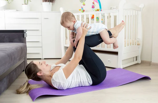 Young mother practicing yoga with her baby boy — Stock Photo, Image