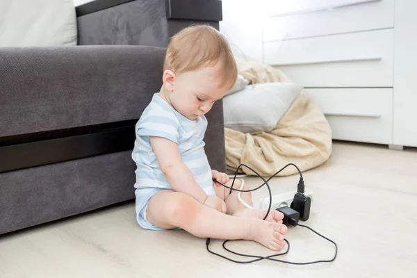 Дитина сидить один у вітальні і грає з електрикою — стокове фото