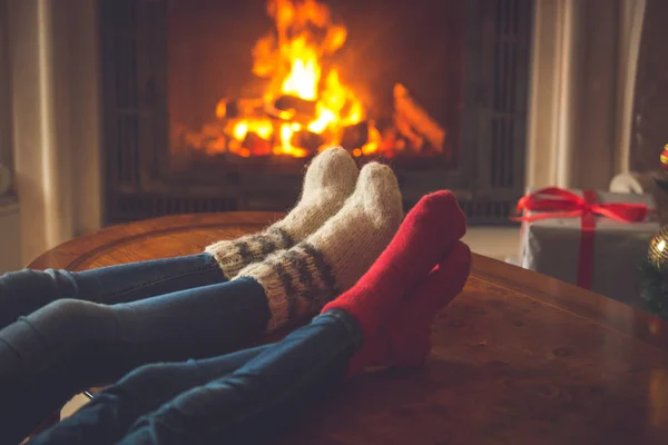 Familia en calcetines de punto acogedor calentamiento en la chimenea decorado para — Foto de Stock