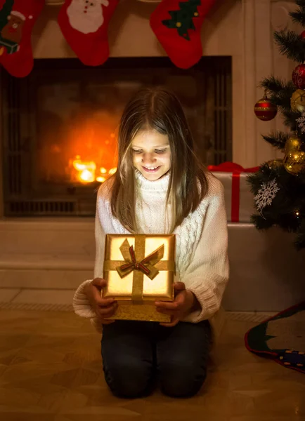 Glad flicka öppna ask med julklapp. Ljus och shin — Stockfoto