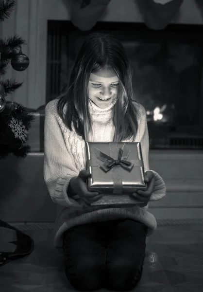 Jeune fille assise sur le sol à la cheminée et l'ouverture de Noël g — Photo