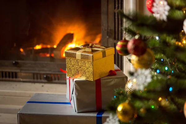 High stack of Christmas presents with burning fireplace — Stock Photo, Image