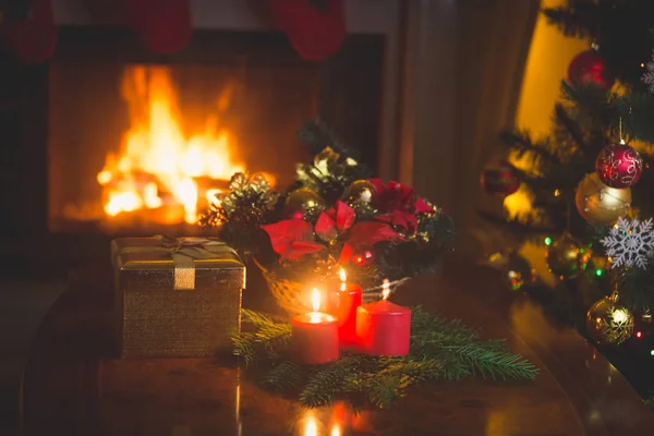 Christmas wreath with red candles in living room with burning fi — Stock Photo, Image