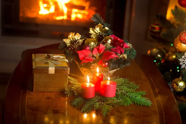 Burning candles by the decorated Christmas tree, giftbox and tra — Stock Photo, Image