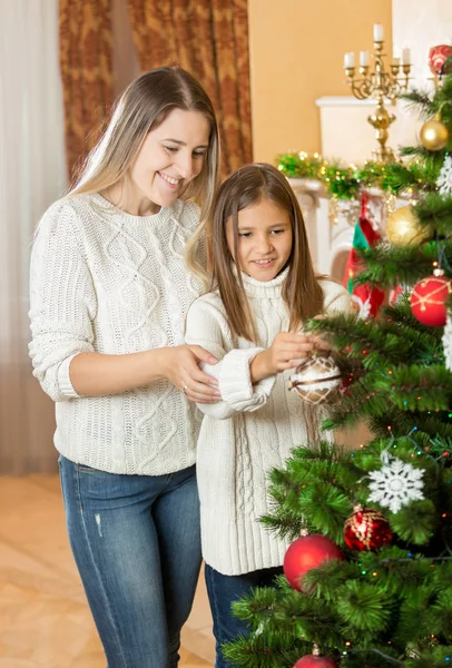 Chica adolescente ayudando a la madre a decorar el árbol de Navidad — Foto de Stock