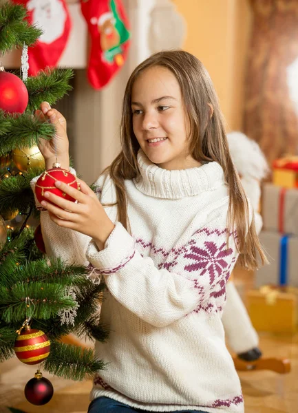 Mooi meisje versieren kerstboom op woonkamer — Stockfoto