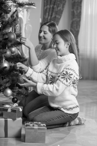 Svartvit bild av glada unga mor och dotter som sitter — Stockfoto