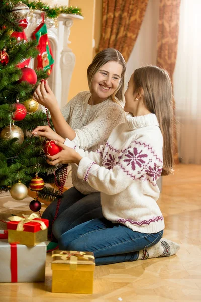 Счастливые мать и дочь сидят на полу в гостиной и де — стоковое фото