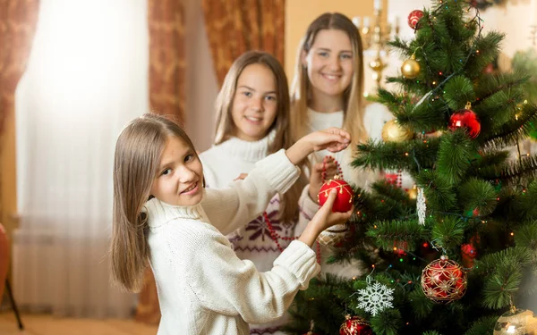 Glücklich lächelnde Familie schmückt Weihnachtsbaum im Wohnzimmer — Stockfoto