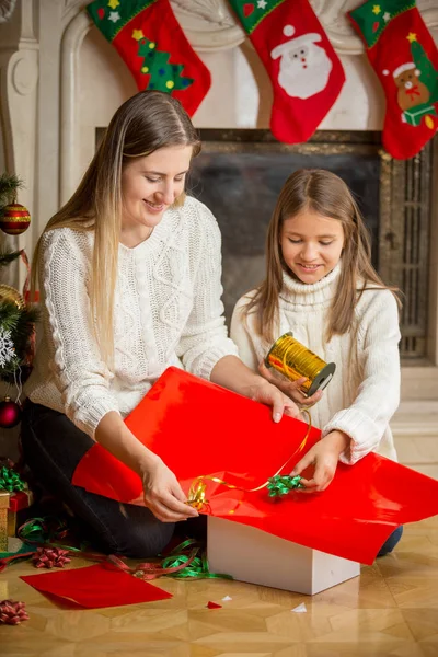 幸せな若い母とかわいい娘クリスマス プレゼントを包装 — ストック写真