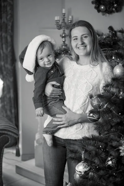 Monochrome portrait of happy mother and baby boy decorating Chri — Stock Photo, Image