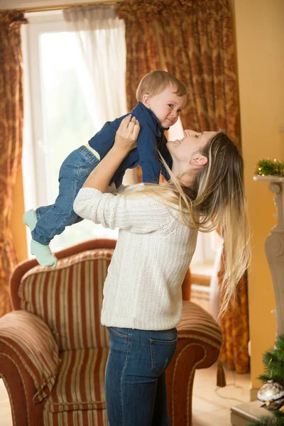 Мать держит на руках 10-месячного сына и украшает рождественскую футболку — стоковое фото