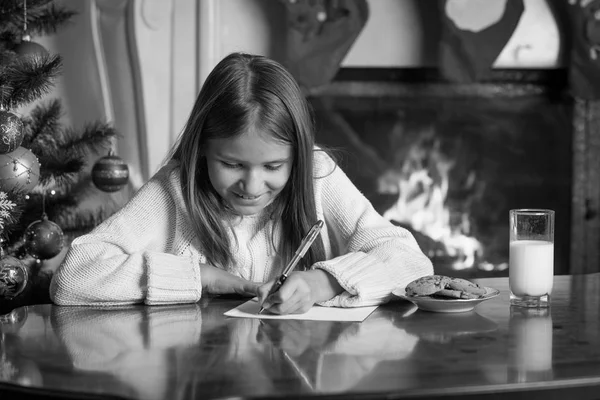 Zwart-wit portret van schattig meisje schrijven brief aan de Kerstman — Stockfoto