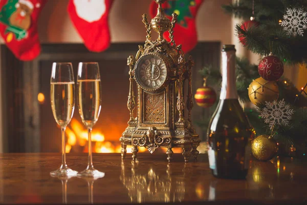 Closeup of two glasses of champagne on table next to old clock s — Stock Photo, Image
