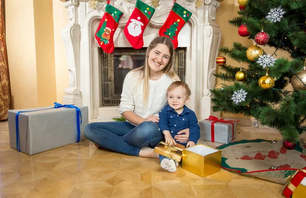 Matku sedící na podlaze se synkem na obývací pokoj zařízený fo — Stock fotografie